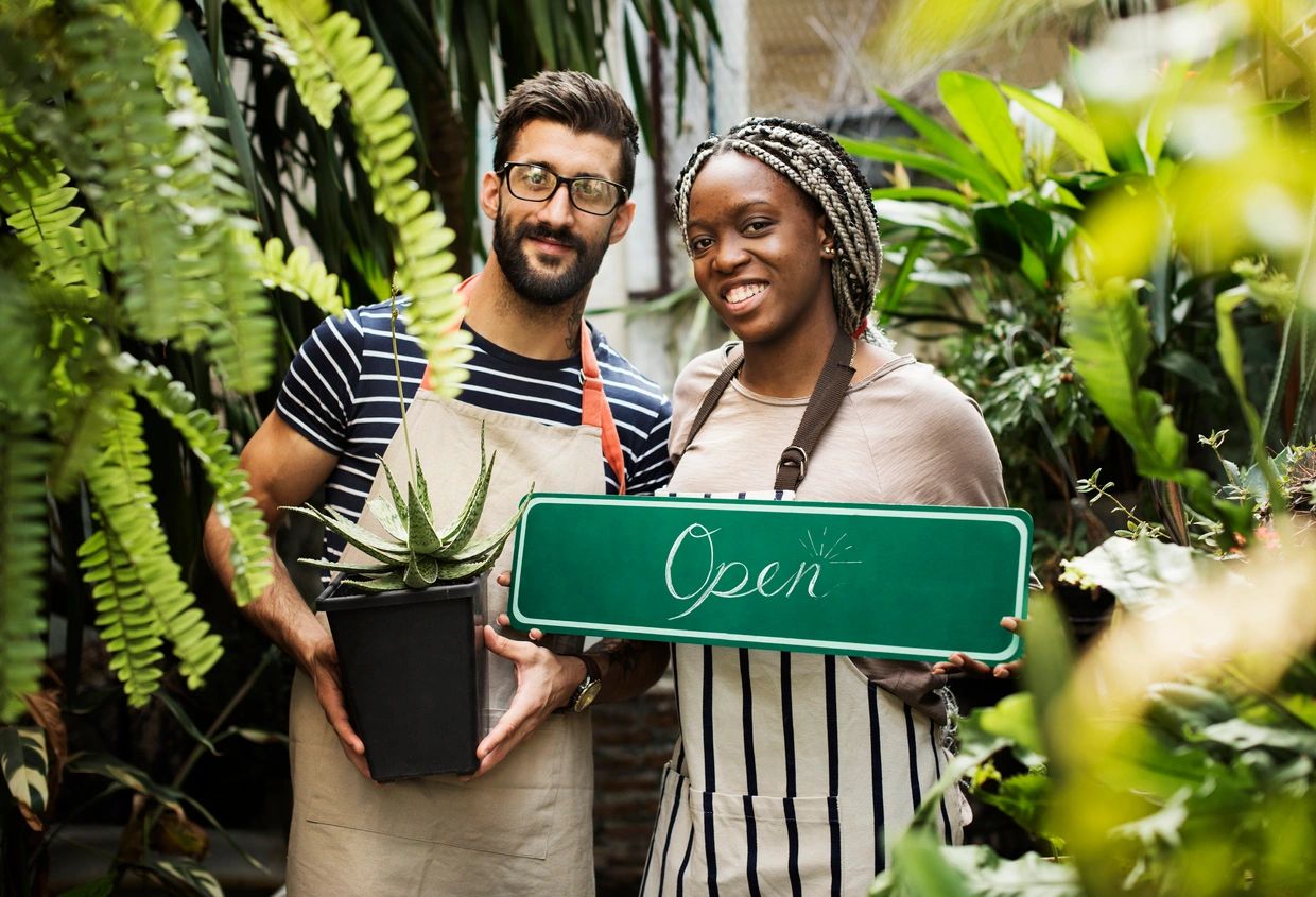 business owners holding an "open" sign